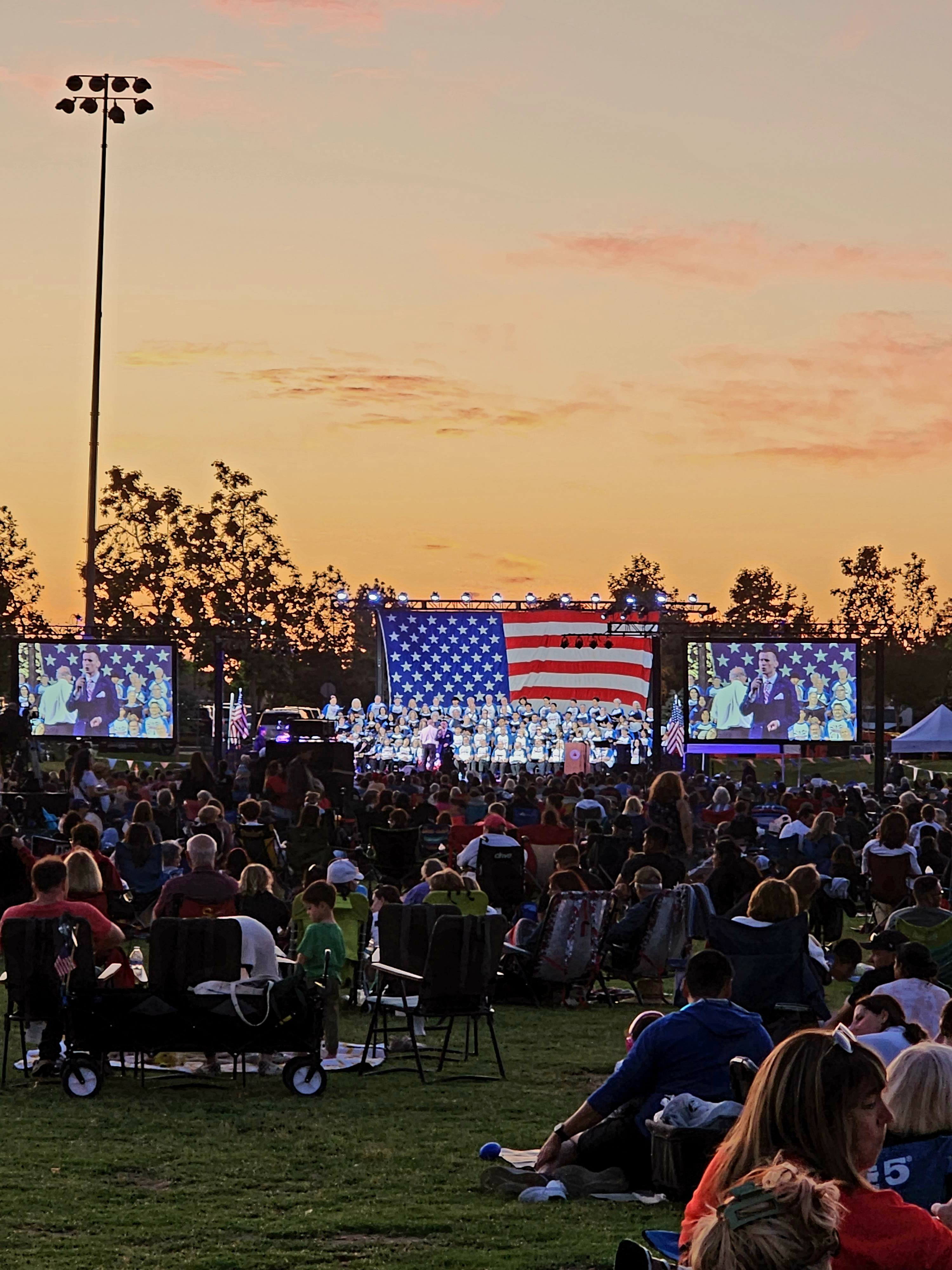 Fourth of July concert and fireworks crowd on the park lawn in Orange, California